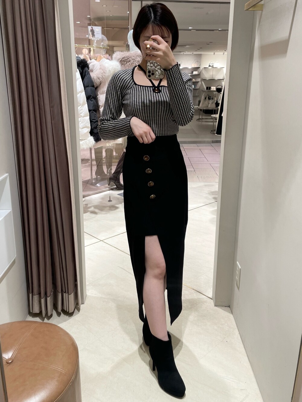 その他のニット/セーター、ブラック系のスカート、ブラック系のブーツを着用したレディースの冬コーディネートの2枚目の写真