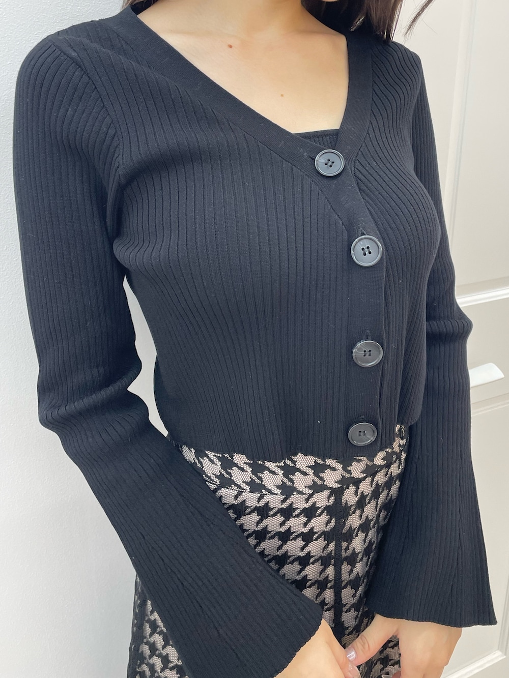 ブラック系のニット/セーター、ブラック系のスカート、ブラック系のブーツを着用したレディースの秋コーディネートの6枚目の写真