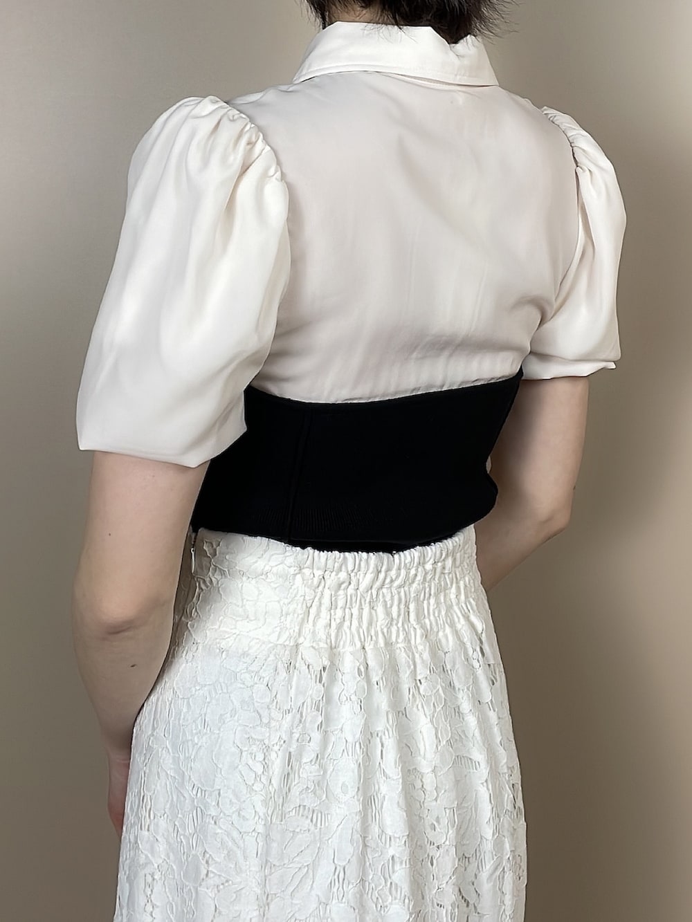 ホワイト系のサンダル、ホワイト系のスカート、ブラック系のニット/セーターを着用したレディースの春コーディネートの6枚目の写真