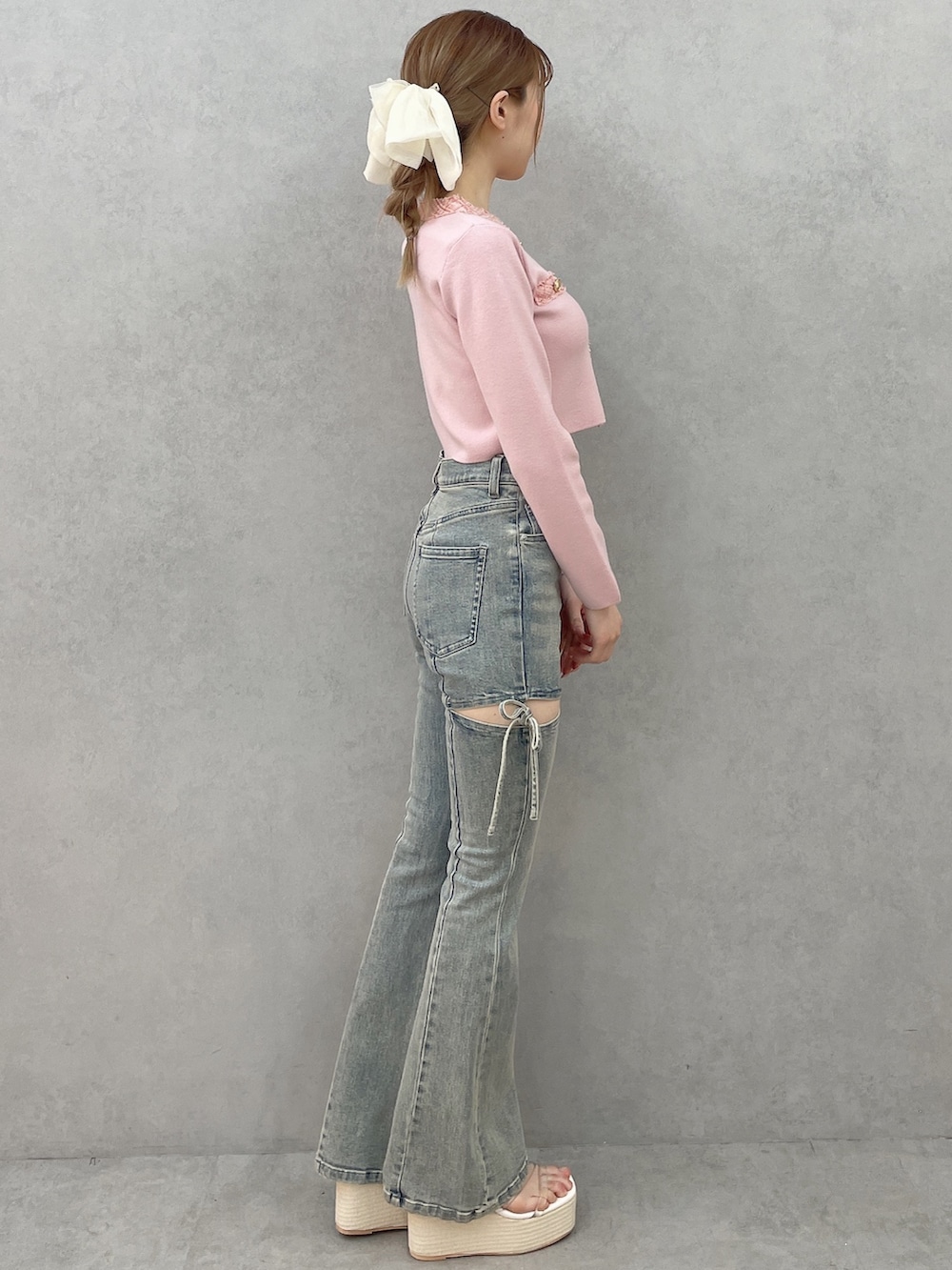 ピンク系のニット/セーター、ブルー系のデニムパンツ、ホワイト系のサンダルを着用したレディースの春コーディネートの3枚目の写真