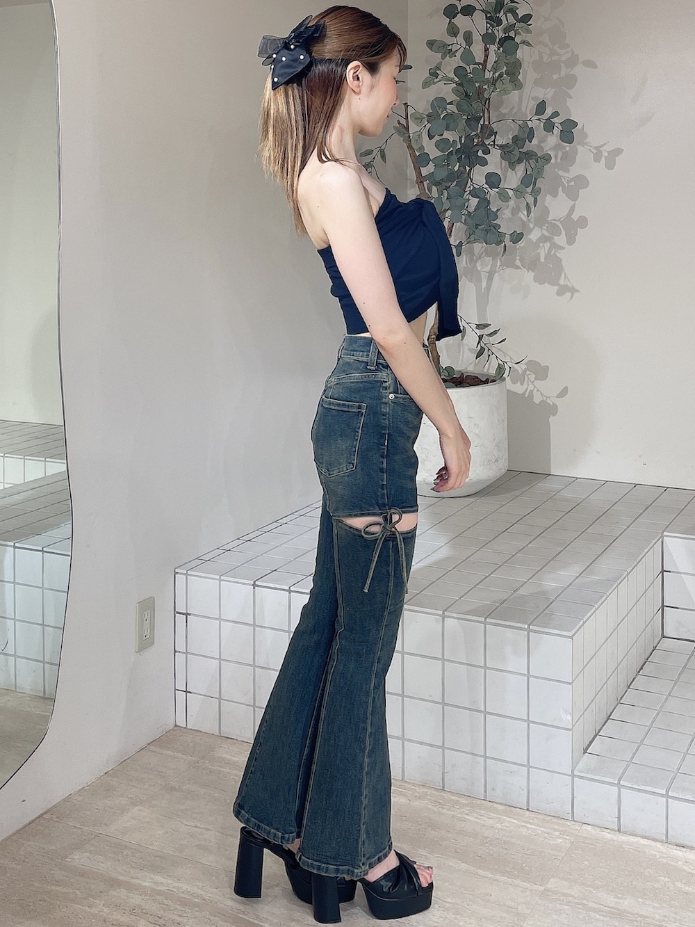 ブラック系のキャミソール、ブルー系のデニムパンツ、ブラック系のサンダルを着用したレディースの夏コーディネートの3枚目の写真