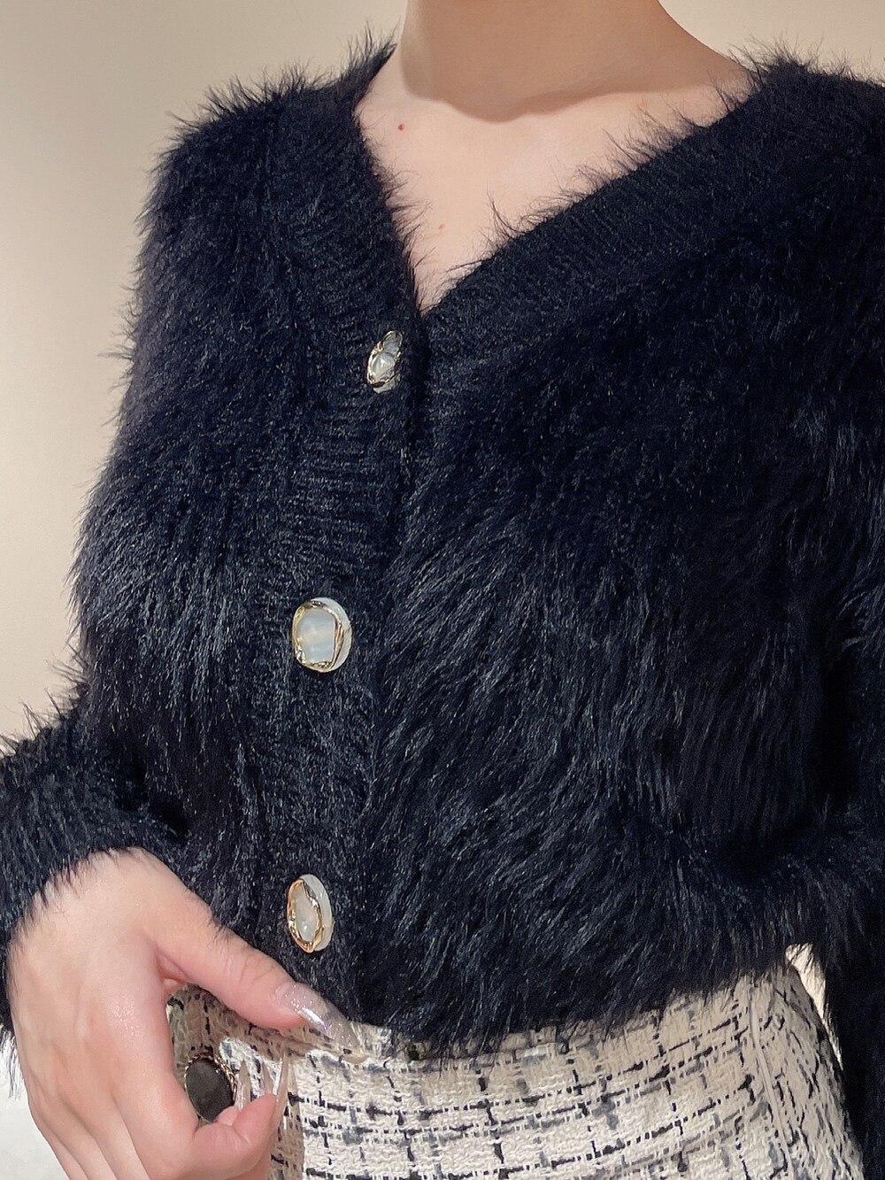 ブラック系のハンドバッグ、ブラック系のカーディガン/ボレロ、ホワイト系のスカートを着用したレディースの秋コーディネートの7枚目の写真