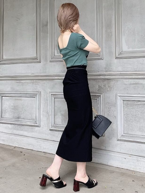 ブラック系のスカート、ブラック系のサンダル、グリーン系のニット/セーターを着用したレディースの春コーディネートの2枚目の写真