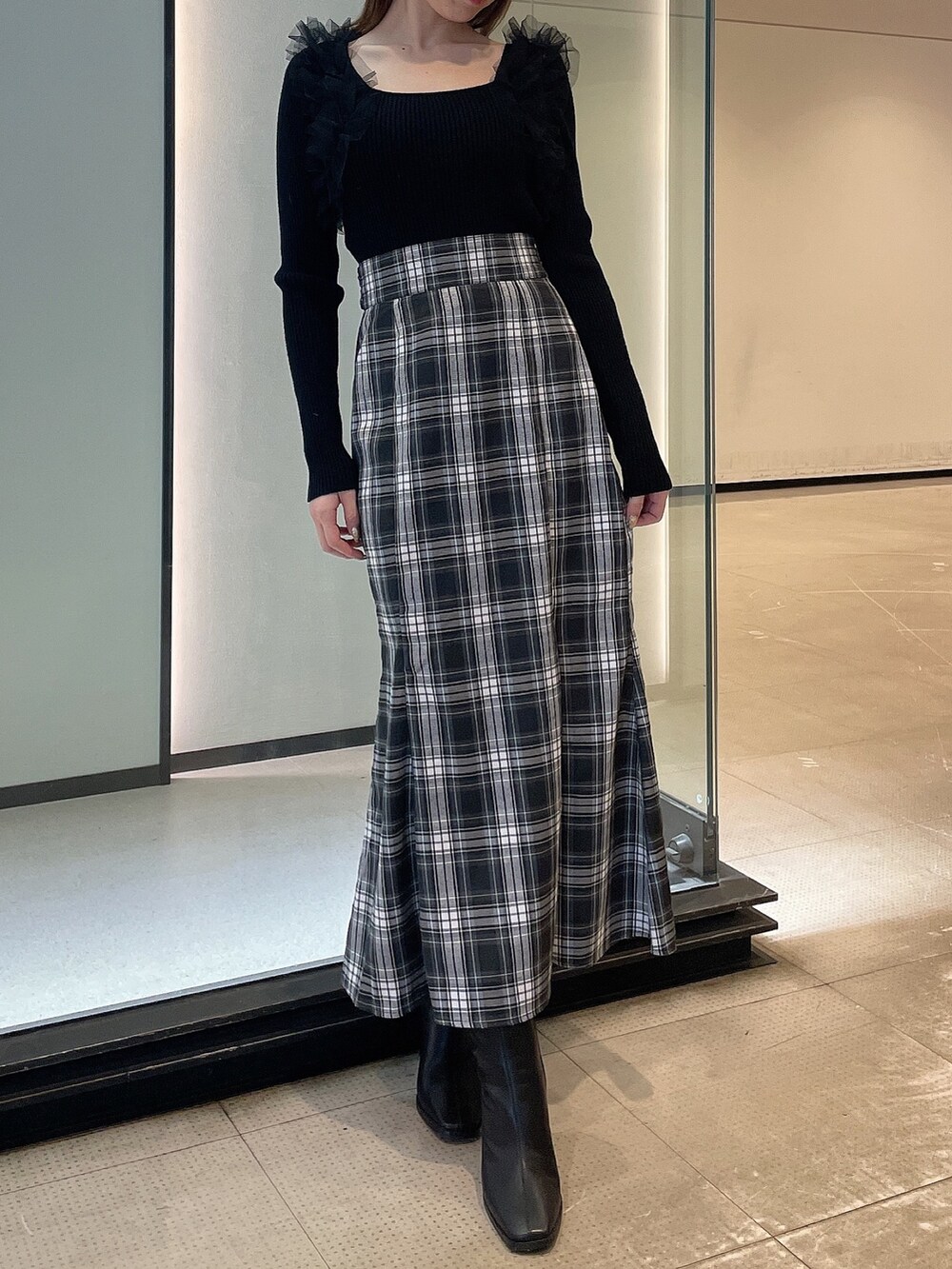 ブラック系のニット/セーター、その他のスカート、ブラック系のブーツを着用したレディースの冬コーディネートの2枚目の写真