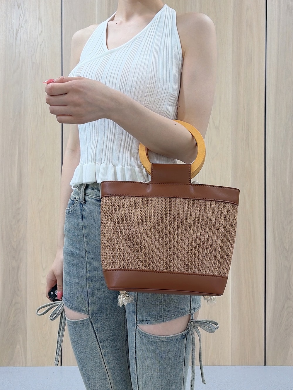 ホワイト系のニット/セーター、ブルー系のデニムパンツ、ブラウン系のハンドバッグを着用したレディースの夏コーディネートの5枚目の写真