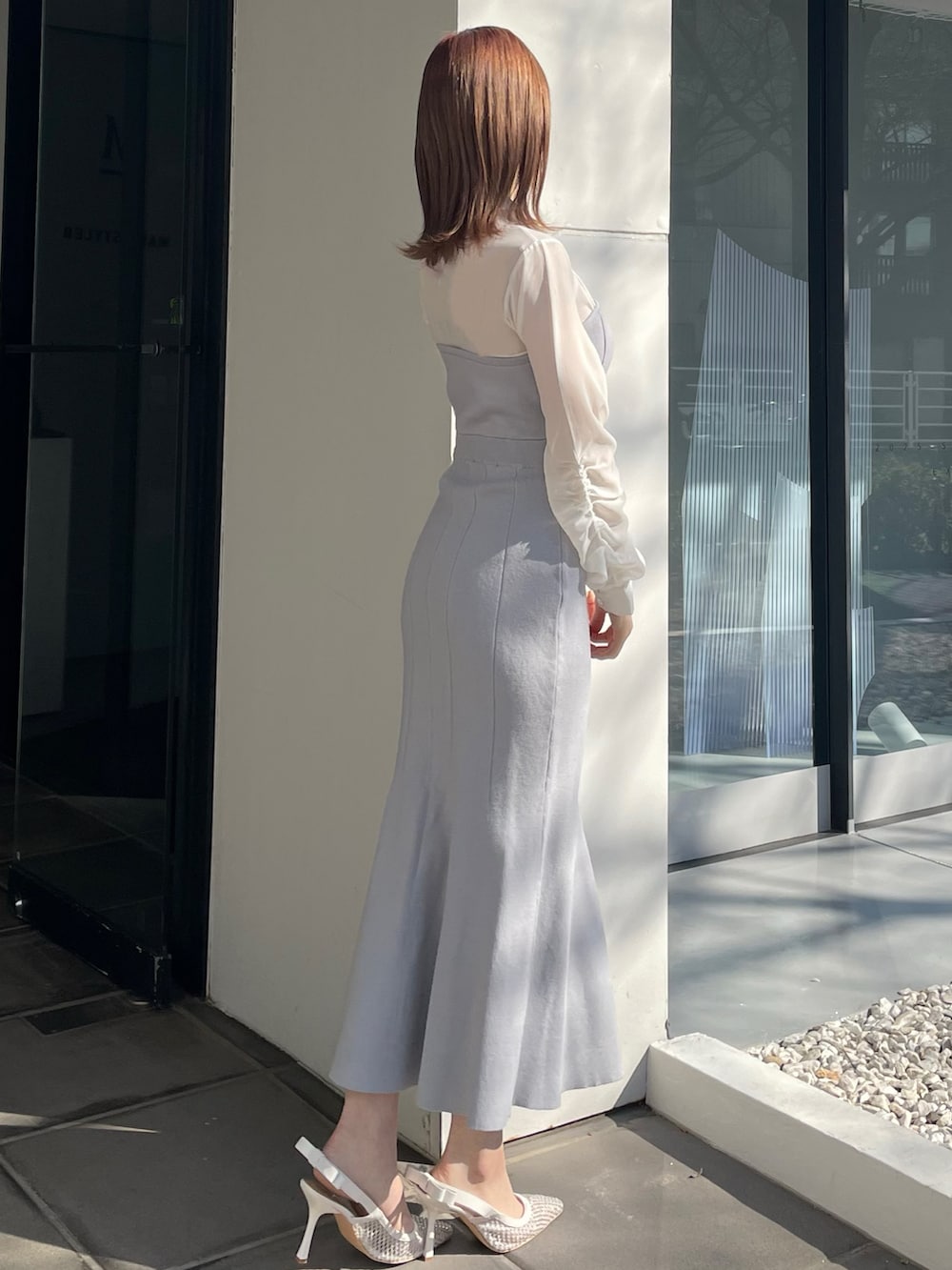 ブルー系のワンピース、ホワイト系のパンプスを着用したレディースの冬コーディネートの2枚目の写真