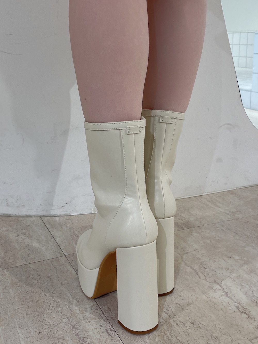 レッド系のニット/セーター、ブルー系のデニムパンツ、ホワイト系のブーツを着用したレディースの冬コーディネートの9枚目の写真