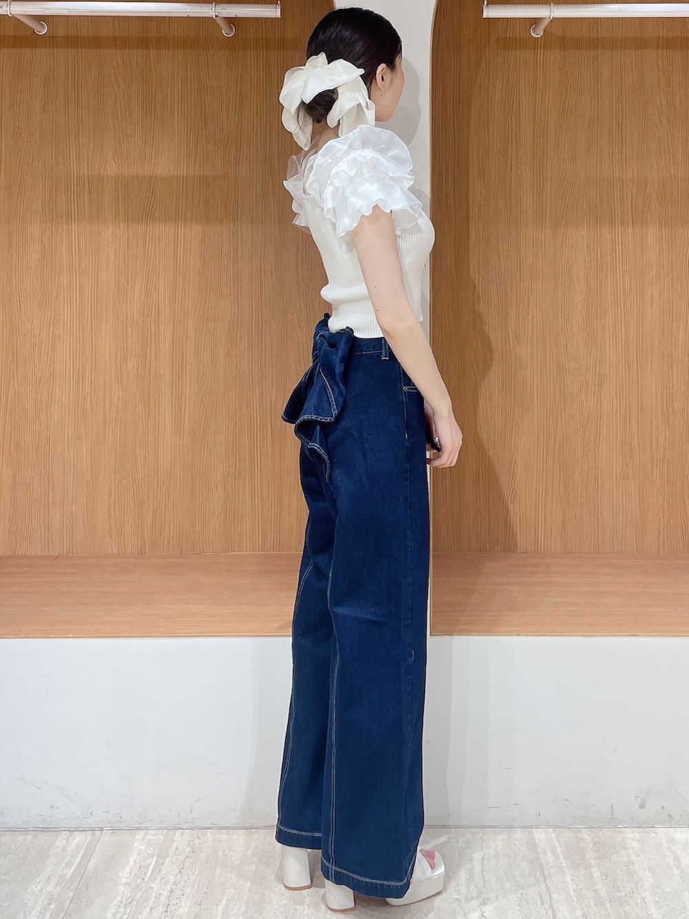 ホワイト系のニット/セーター、ブルー系のデニムパンツ、ホワイト系のサンダルを着用したレディースの春コーディネートの3枚目の写真