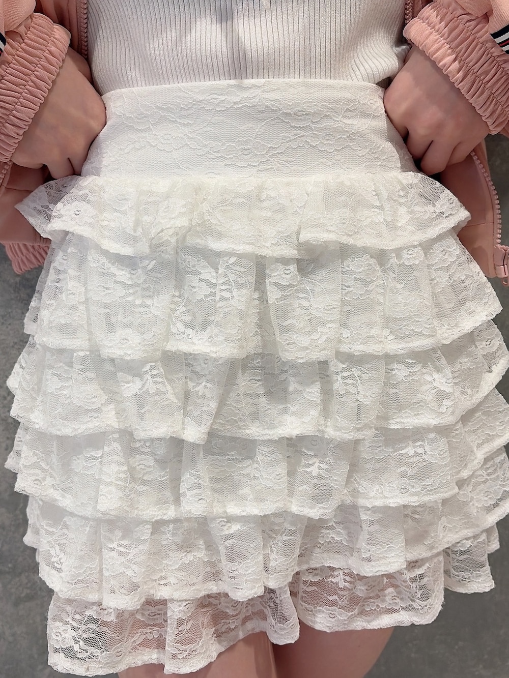 ピンク系のその他アウター、ホワイト系のスカート、ホワイト系のニット/セーターを着用したレディースの冬コーディネートの7枚目の写真