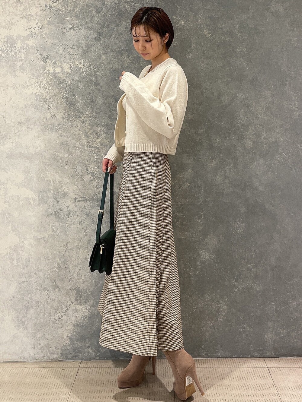 ホワイト系のカーディガン/ボレロ、グリーン系のショルダーバッグ、ベージュ系のブーツを着用したレディースの秋コーディネートの4枚目の写真