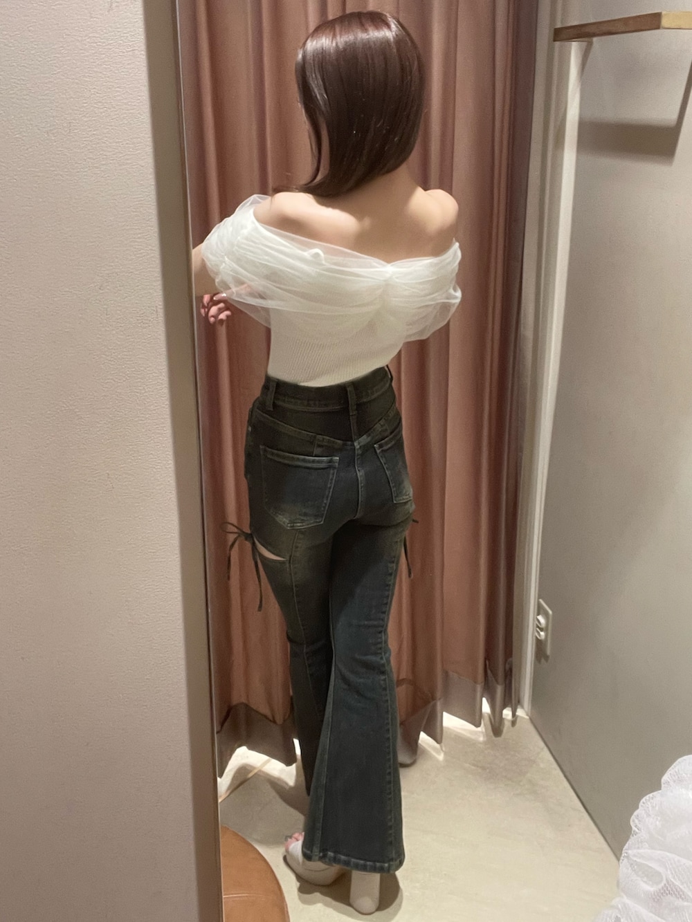 ホワイト系のニット/セーター、ブルー系のデニムパンツ、ベージュ系のサンダルを着用したレディースの春コーディネートの4枚目の写真