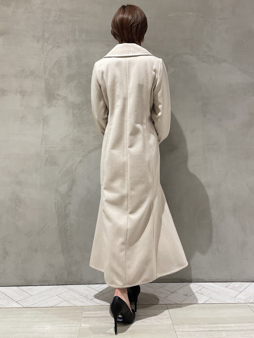 ベージュ系のその他アウター、グレー系のワンピース、ブラック系のハンドバッグを着用したレディースの冬コーディネートの4枚目の写真