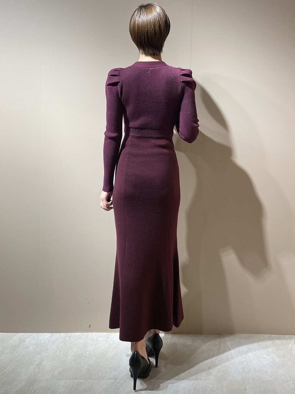 レッド系のワンピース、ブラック系のパンプスを着用したレディースの秋コーディネートの5枚目の写真