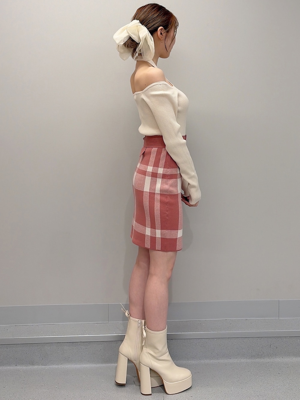 オレンジ系のワンピース、ホワイト系のブーツ、ホワイト系のバレッタ/ヘアクリップを着用したレディースの冬コーディネートの3枚目の写真