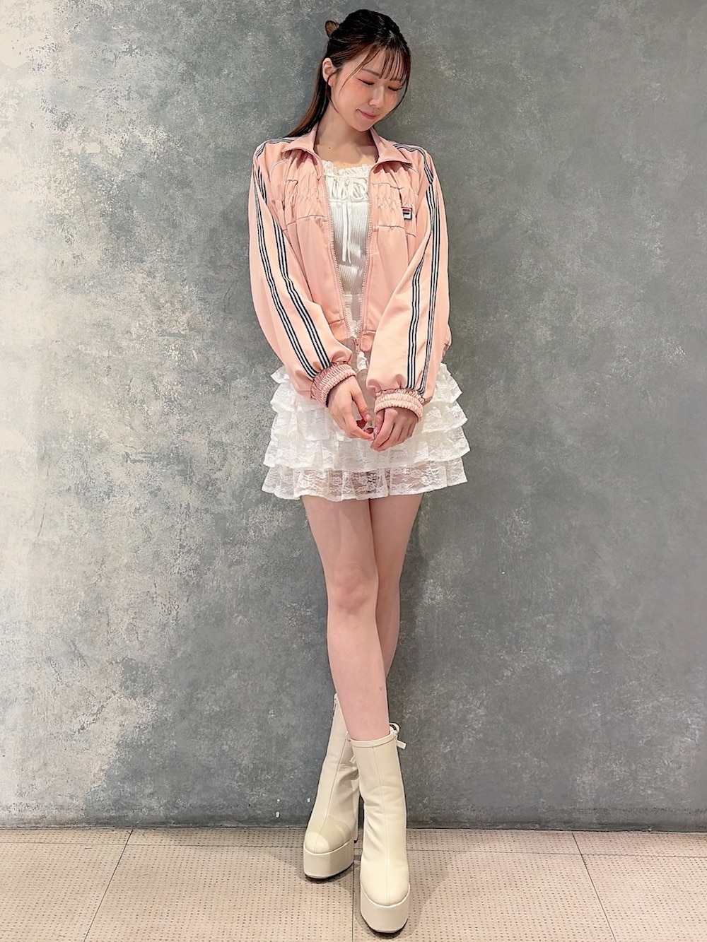 ピンク系のその他アウター、ホワイト系のスカート、ホワイト系のニット/セーターを着用したレディースの冬コーディネートの2枚目の写真