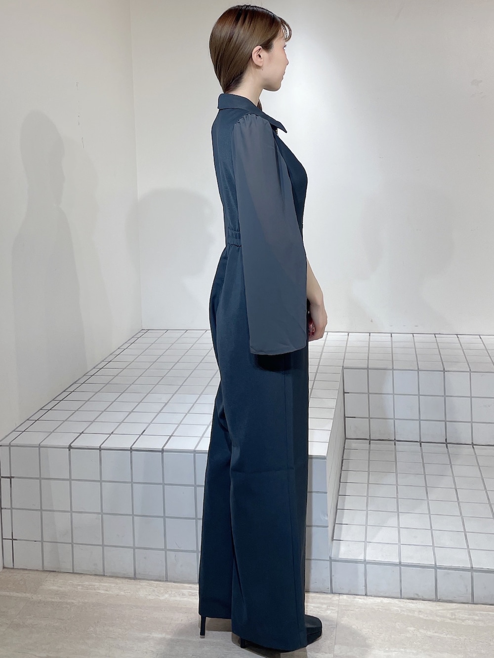 グレー系のワンピース、ブラック系のブーツを着用したレディースの冬コーディネートの3枚目の写真