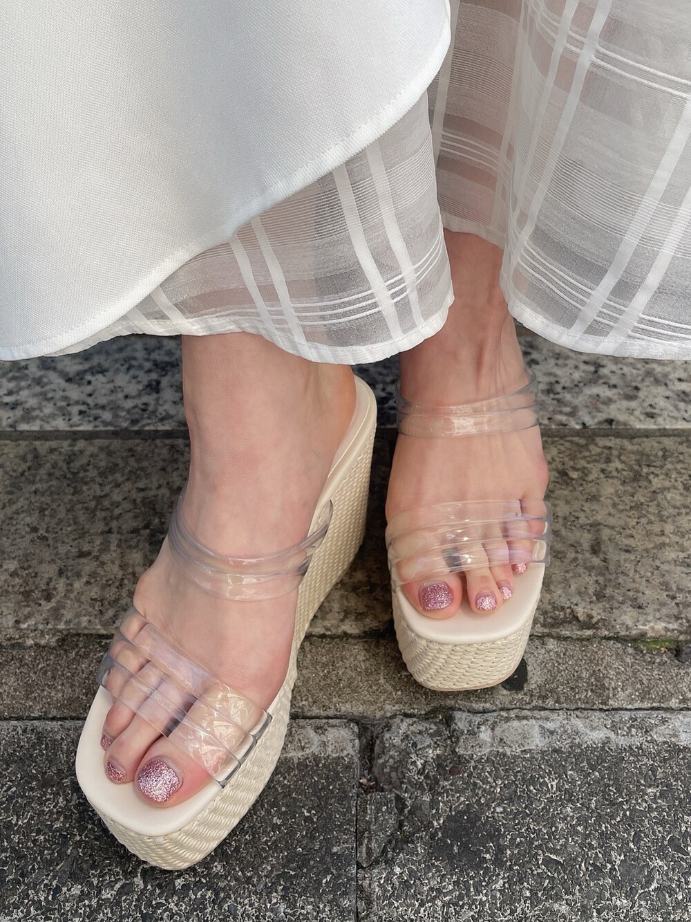 ホワイト系のカーディガン/ボレロ、ブラック系のワンピース、ホワイト系のサンダルを着用したレディースの夏コーディネートの9枚目の写真