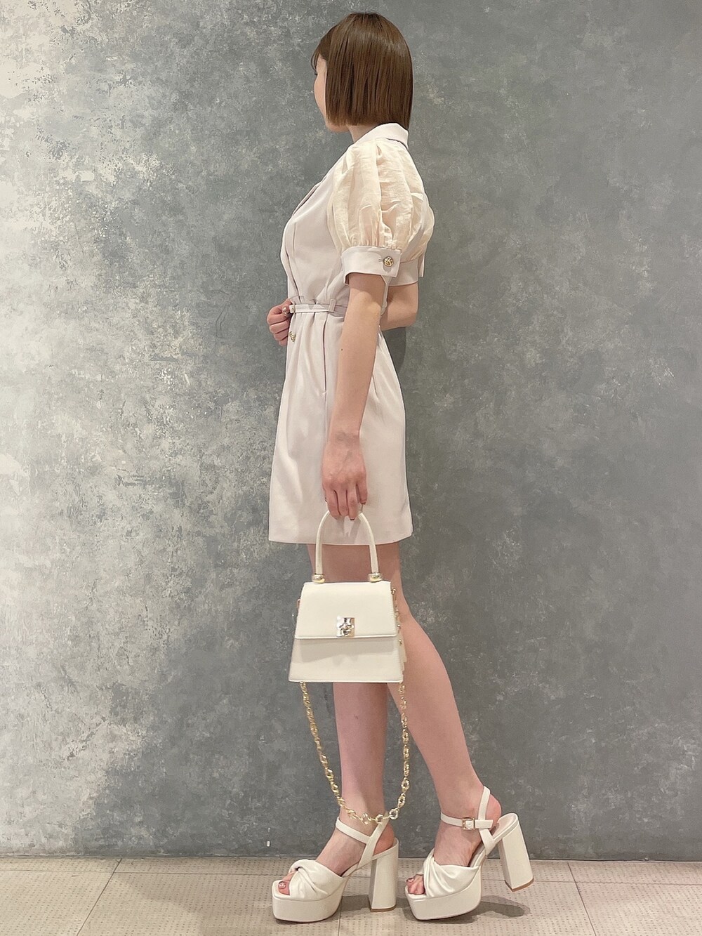 ホワイト系のワンピース、ホワイト系のハンドバッグ、ホワイト系のサンダルを着用したレディースの春コーディネートの3枚目の写真