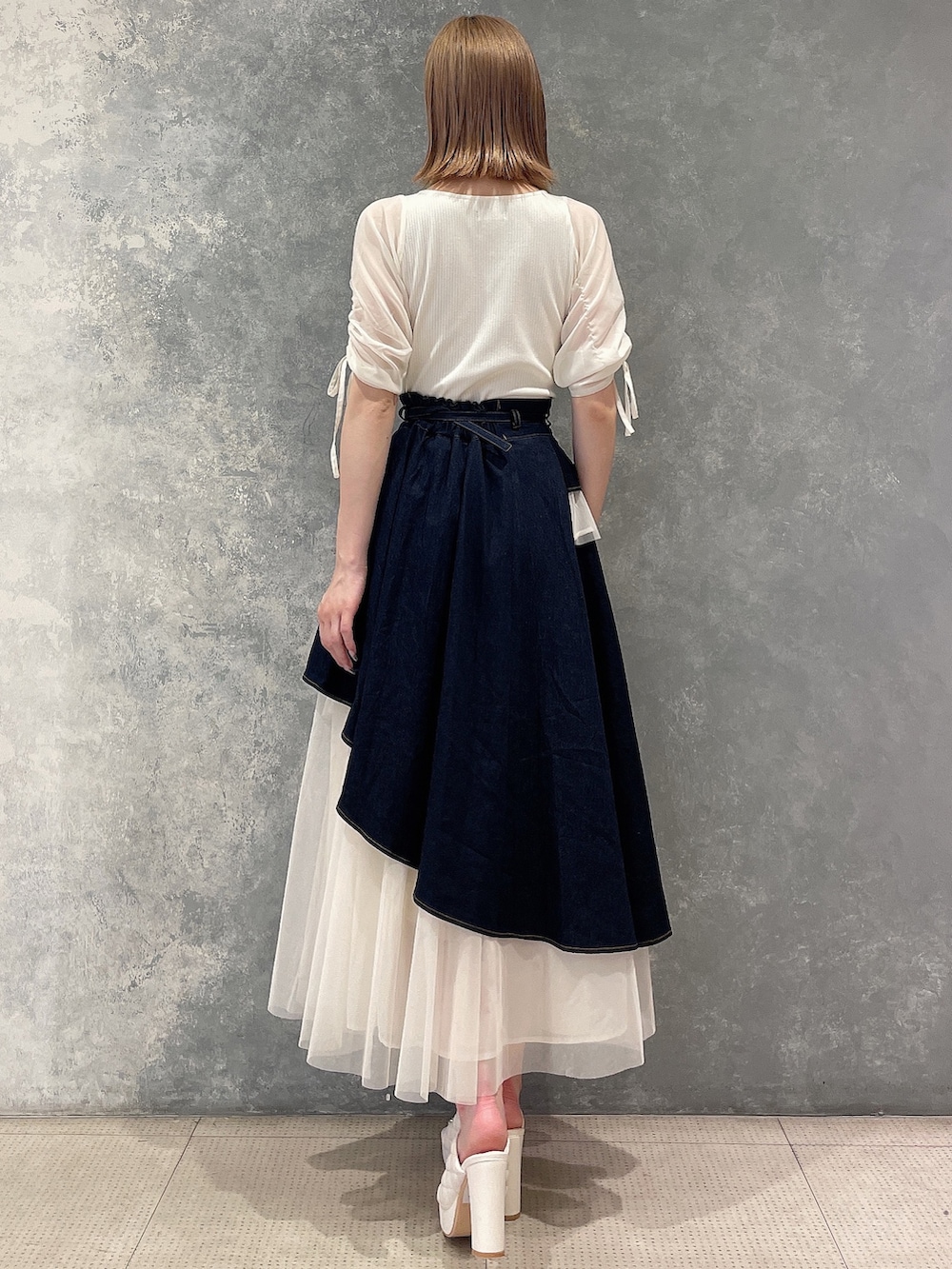 ホワイト系のTシャツ/カットソー、ブルー系のデニムスカート、ホワイト系のサンダルを着用したレディースの夏コーディネートの3枚目の写真