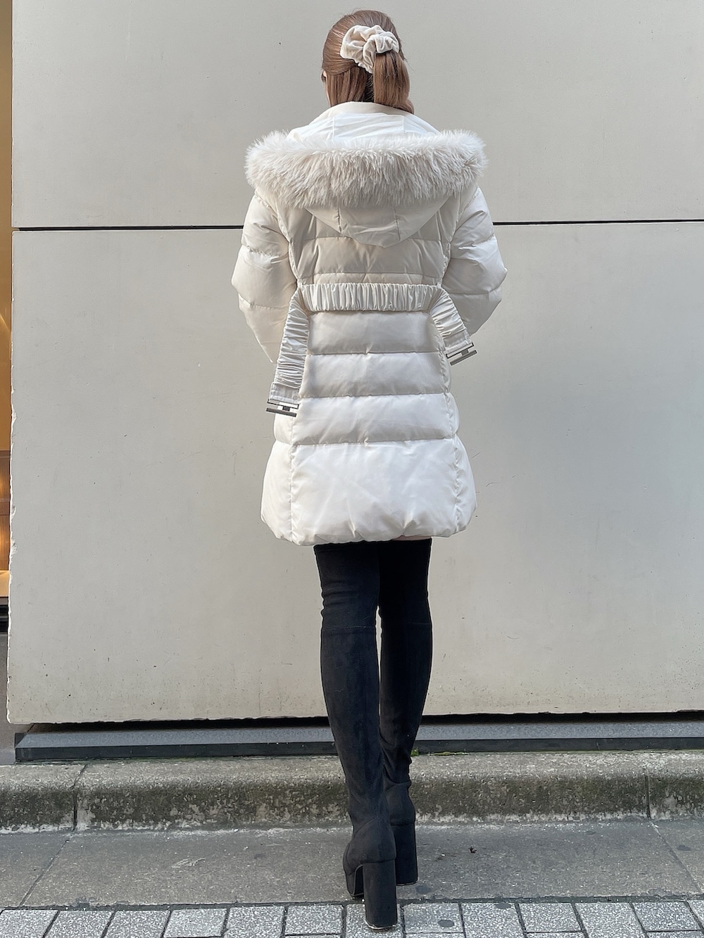 ブラック系のブーツ、パープル系のワンピース、ホワイト系のダウンジャケット/コートを着用したレディースの秋コーディネートの4枚目の写真