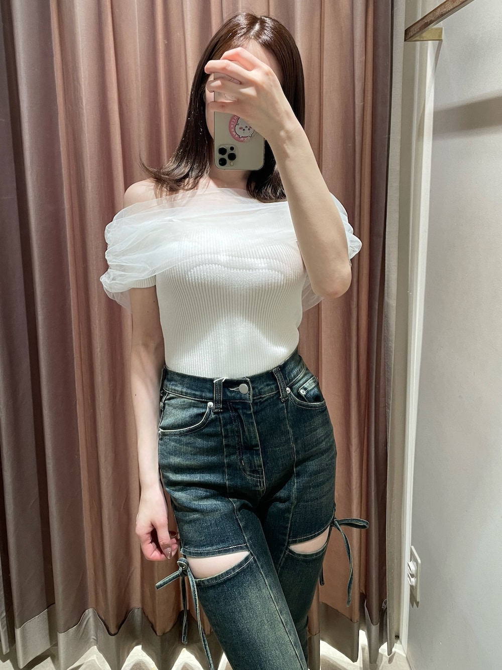 ホワイト系のニット/セーター、ブルー系のデニムパンツ、ベージュ系のサンダルを着用したレディースの春コーディネートの5枚目の写真