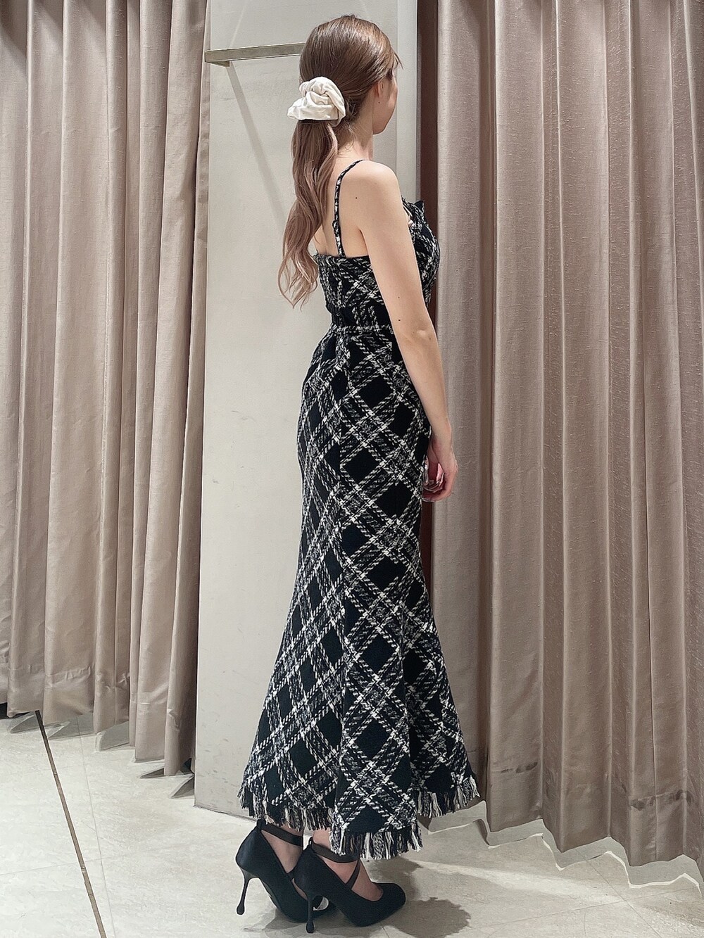 グレー系のカーディガン/ボレロ、ブラック系のワンピース、ブラック系のパンプスを着用したレディースの秋コーディネートの5枚目の写真