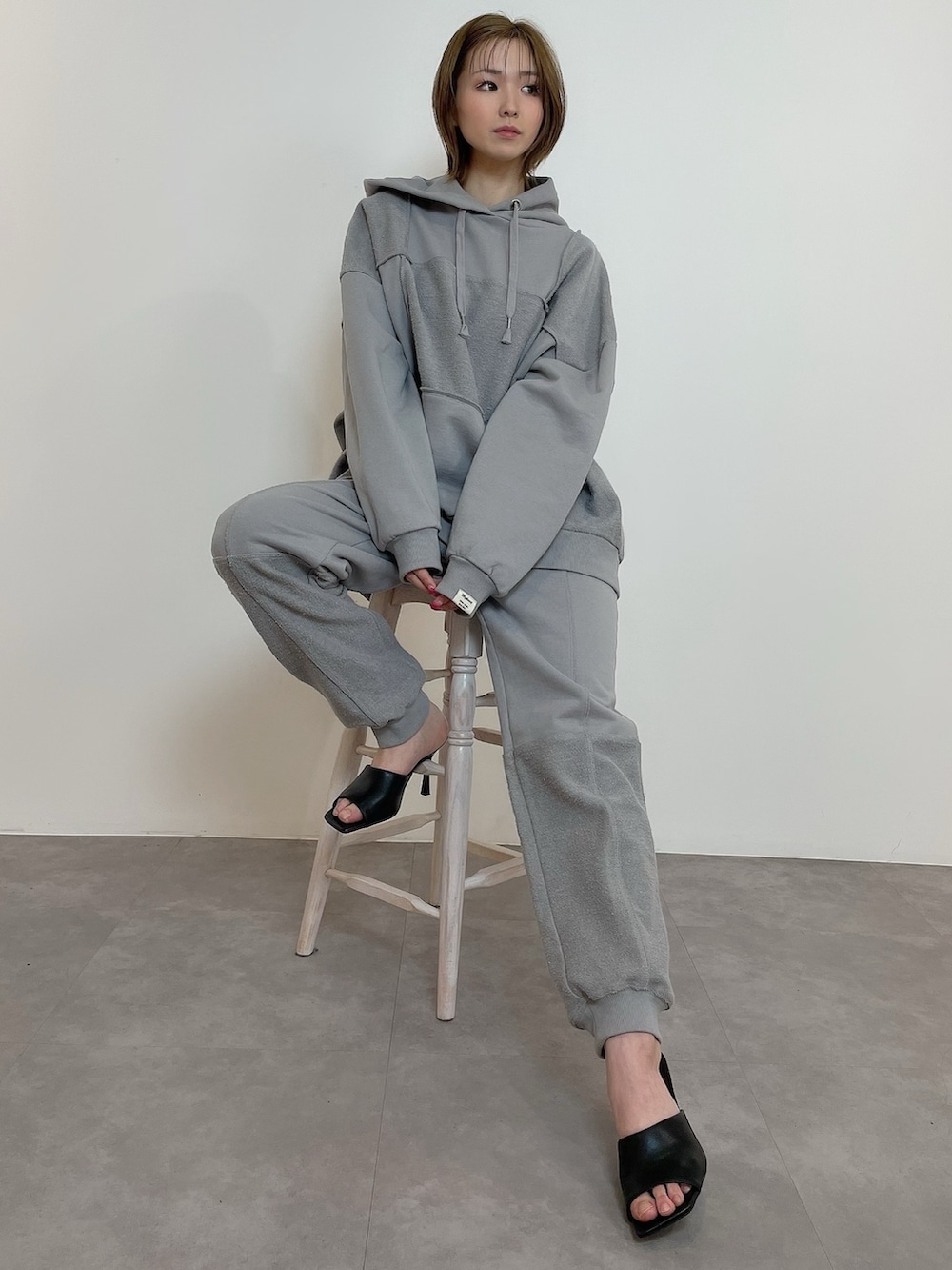 グレー系のスウェット、グレー系のスウェットパンツ、ブラック系のサンダルを着用したレディースの冬コーディネートの5枚目の写真
