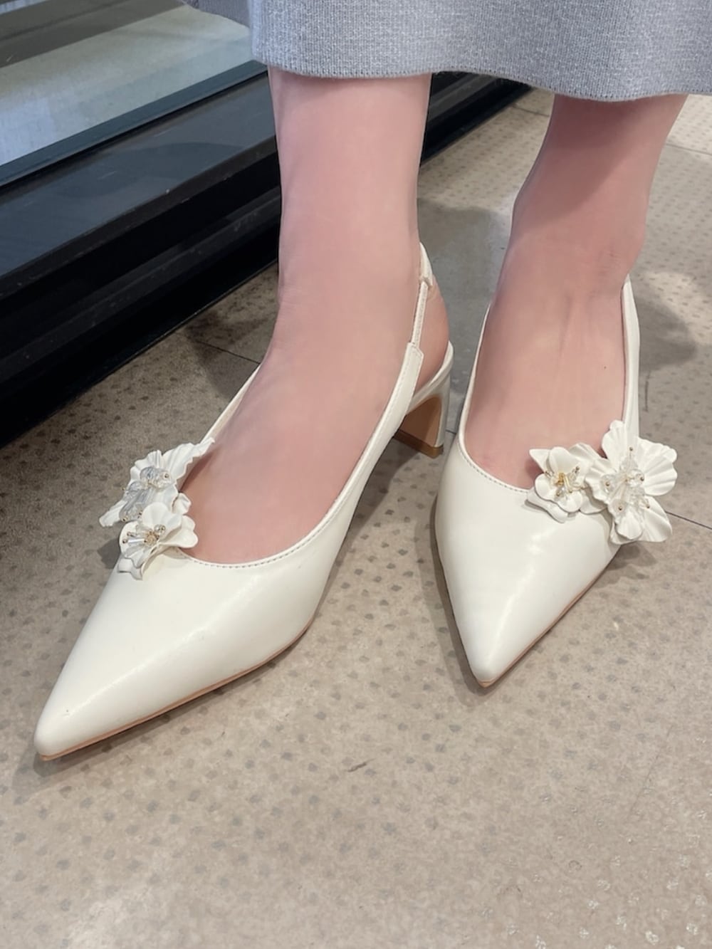 ホワイト系のテーラードジャケット、ブルー系のワンピース、ホワイト系のパンプスを着用したレディースの冬コーディネートの8枚目の写真