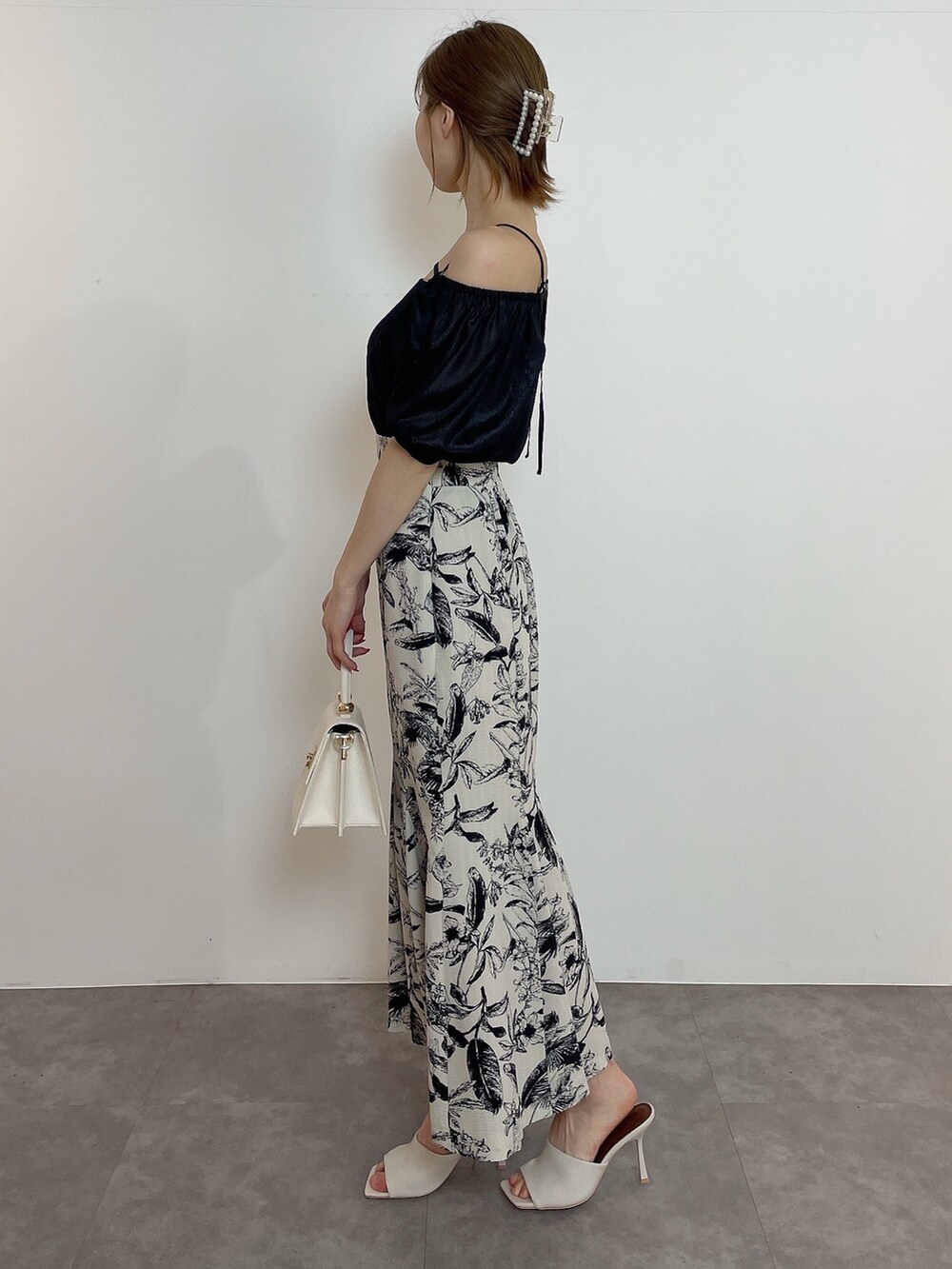 ホワイト系のハンドバッグ、ブラック系のシャツ/ブラウス、その他のスカートを着用したレディースの春コーディネートの3枚目の写真