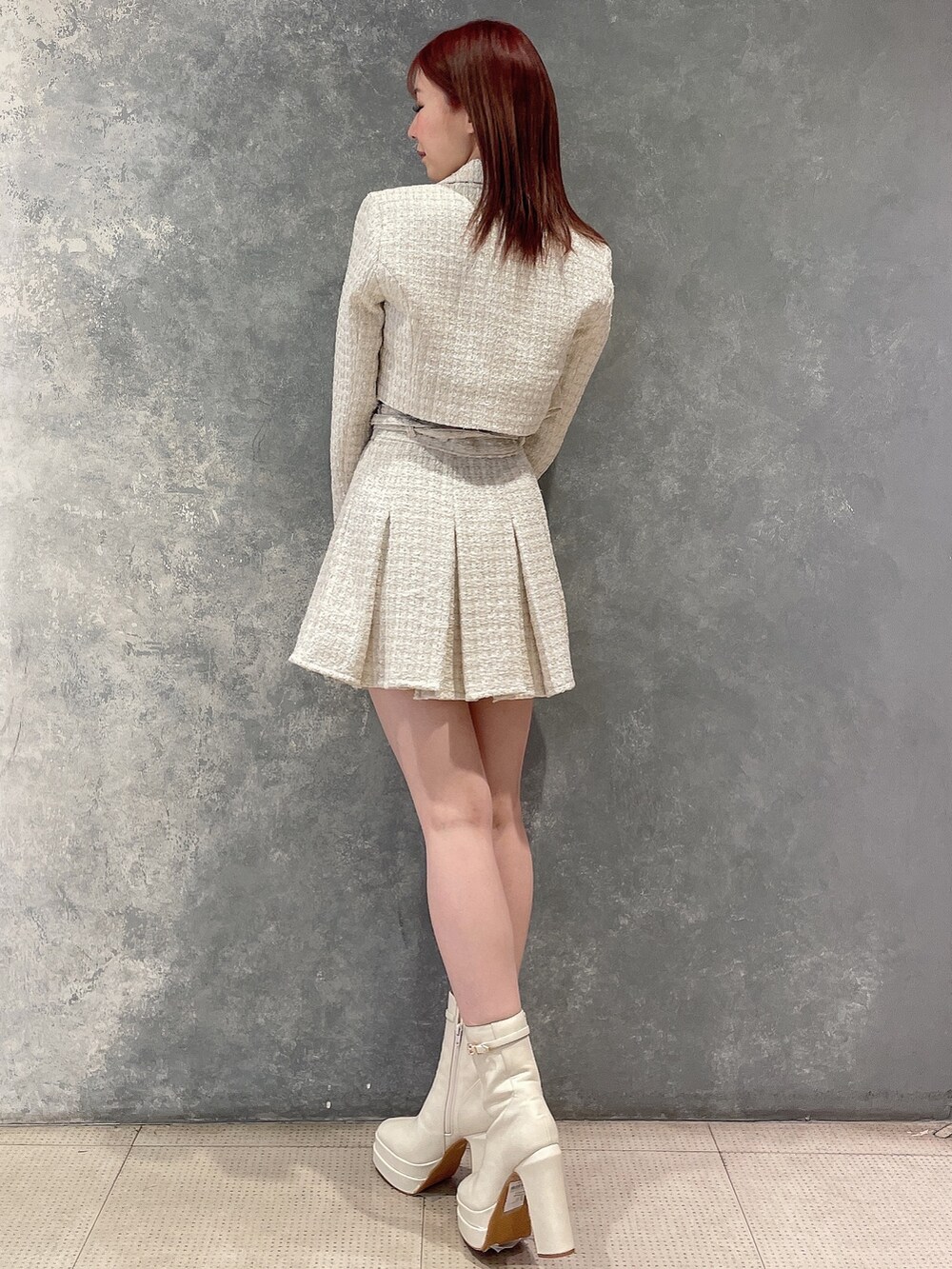 ホワイト系のテーラードジャケット、ホワイト系のスカート、ブラック系のニット/セーターを着用したレディースの冬コーディネートの4枚目の写真