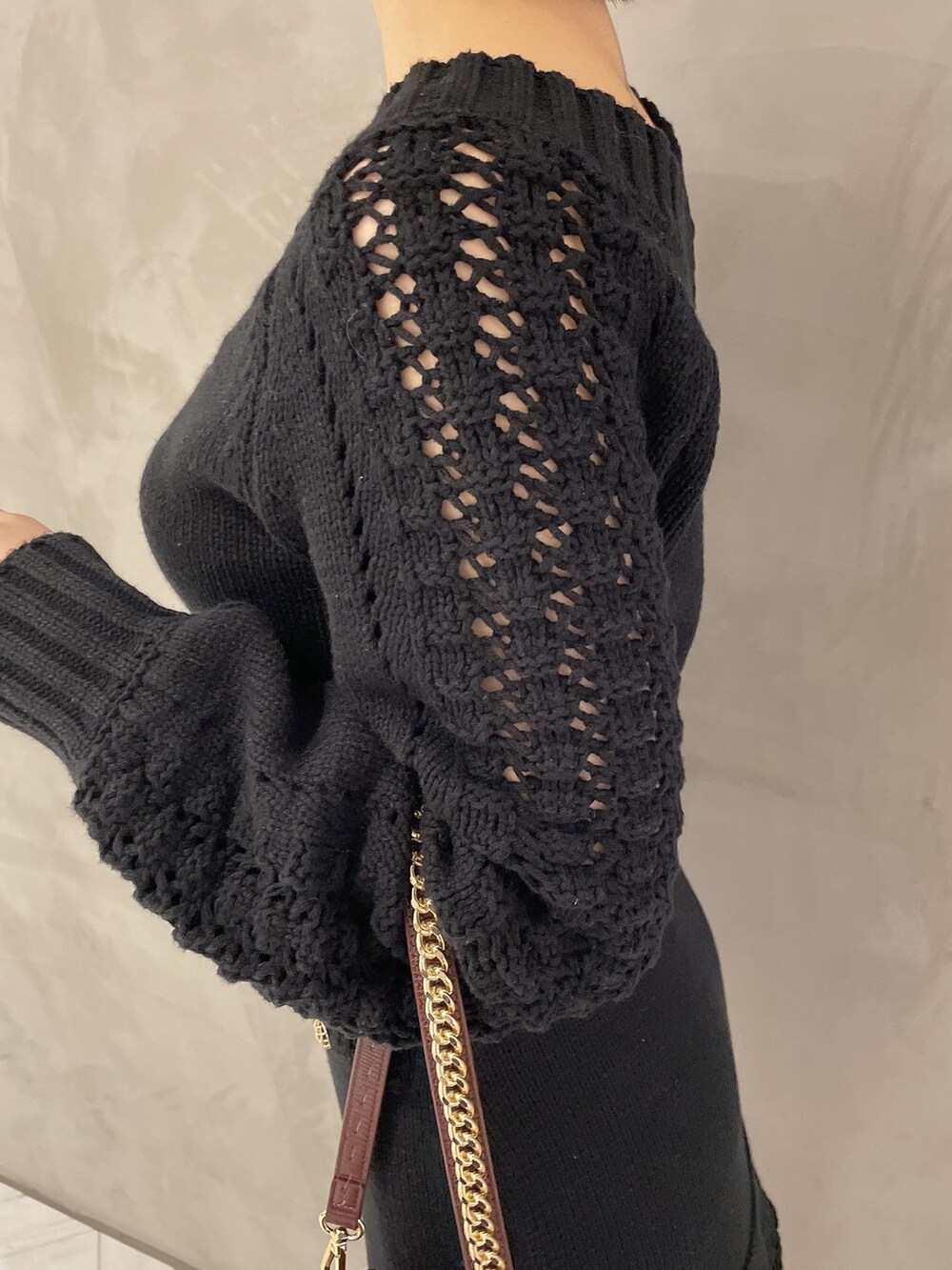 ブラウン系のハンドバッグ、ブラック系のブーツ、ブラック系のニット/セーターを着用したレディースの秋コーディネートの7枚目の写真