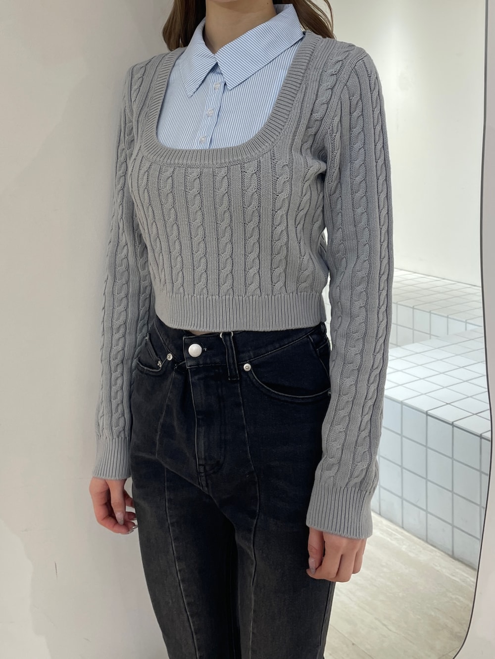 グレー系のニット/セーター、ブラック系のデニムパンツ、ブラック系のブーツを着用したレディースの冬コーディネートの4枚目の写真