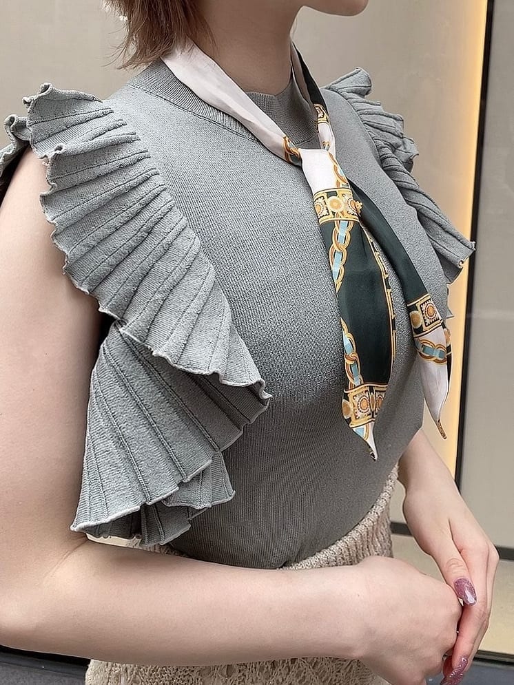 ベージュ系のスカート、ホワイト系のサンダル、グリーン系のニット/セーターを着用したレディースの春コーディネートの5枚目の写真