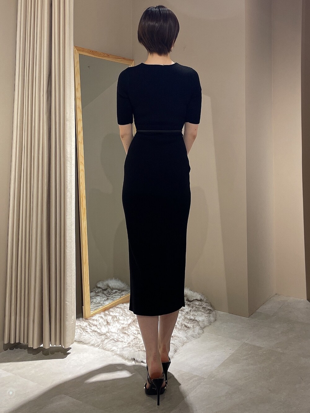 ブラック系のワンピース、ブラック系のパンプス、ブラック系のベルトを着用したレディースの春コーディネートの6枚目の写真