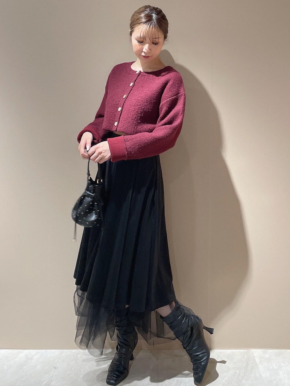 ブラック系のブーツ、レッド系のカーディガン/ボレロ、ブラック系のハンドバッグを着用したレディースの秋コーディネートの3枚目の写真