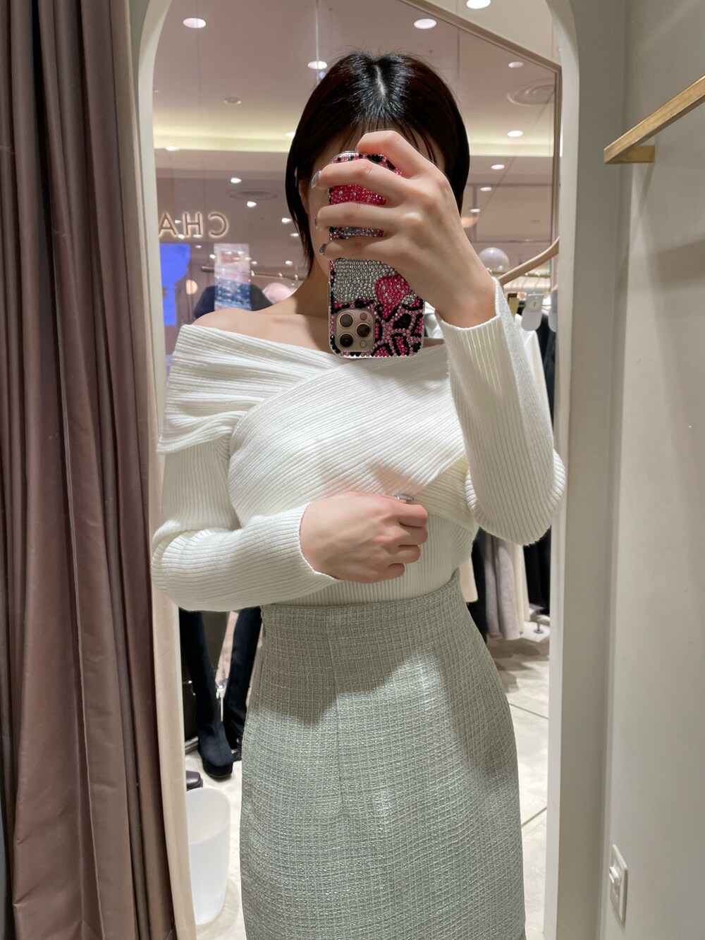 ホワイト系のニット/セーター、グリーン系のスカート、ブラック系のブーツを着用したレディースの冬コーディネートの4枚目の写真