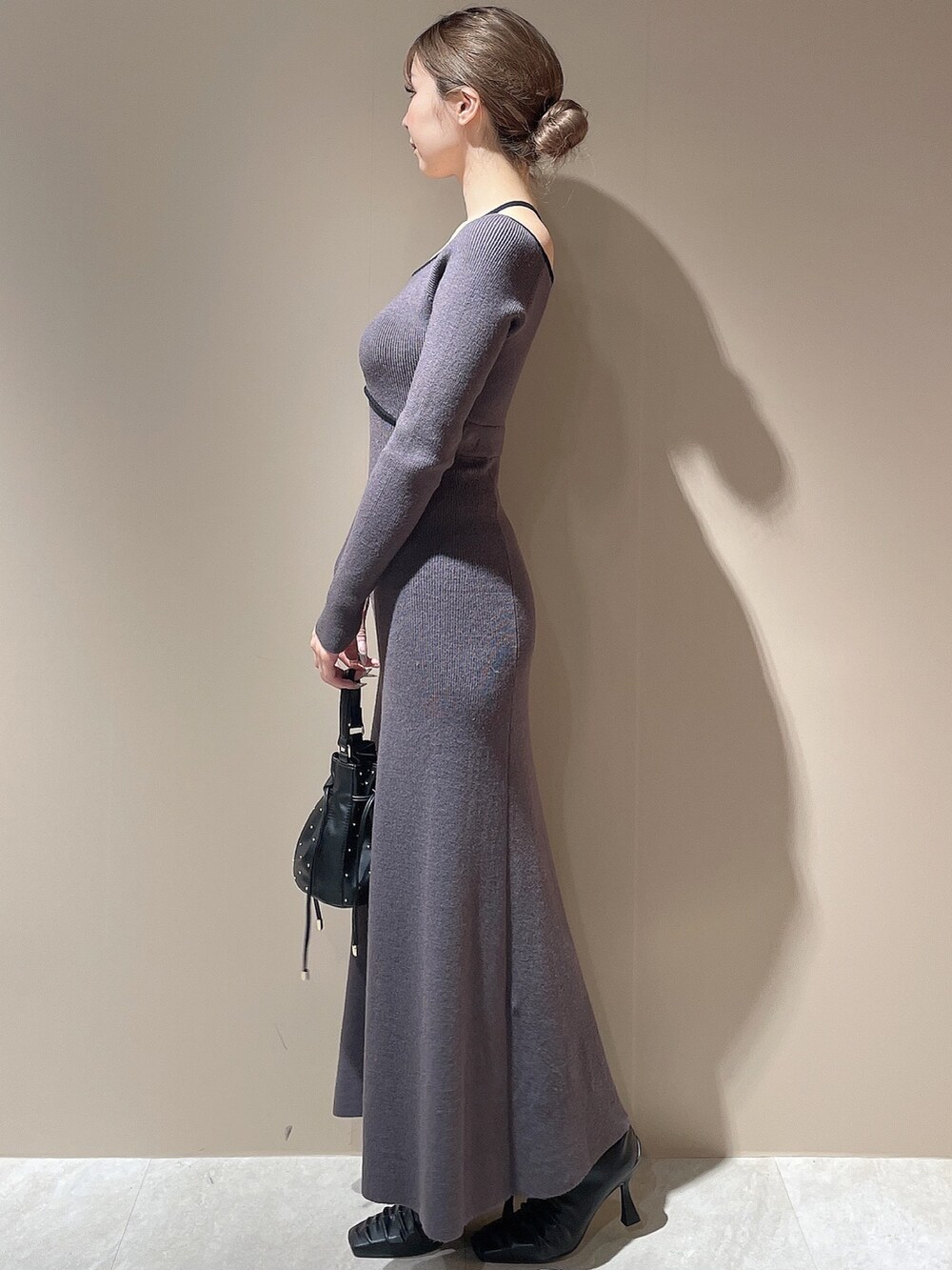 ブラック系のライダースジャケット、グレー系のワンピース、ブラック系のハンドバッグを着用したレディースの秋コーディネートの5枚目の写真