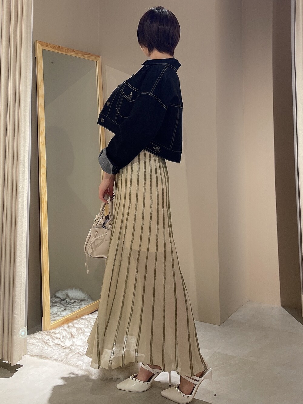 ホワイト系のワンピース、ブラック系のデニムジャケットを着用したレディースの春コーディネートの2枚目の写真