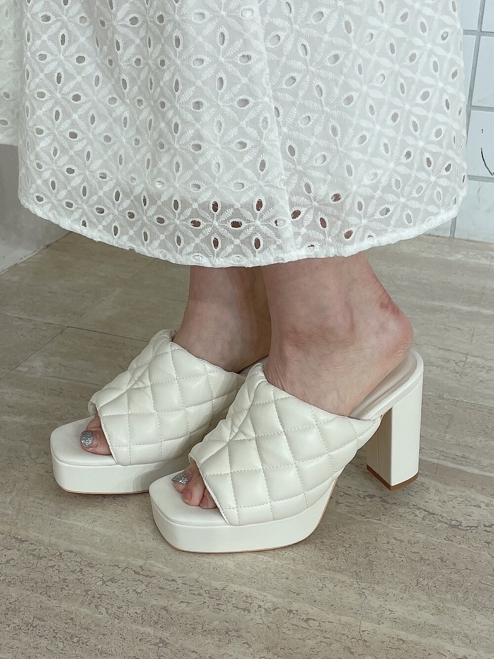 ホワイト系のサンダル、ブルー系のデニムパンツ、ホワイト系のキャミソールを着用したレディースの夏コーディネートの7枚目の写真