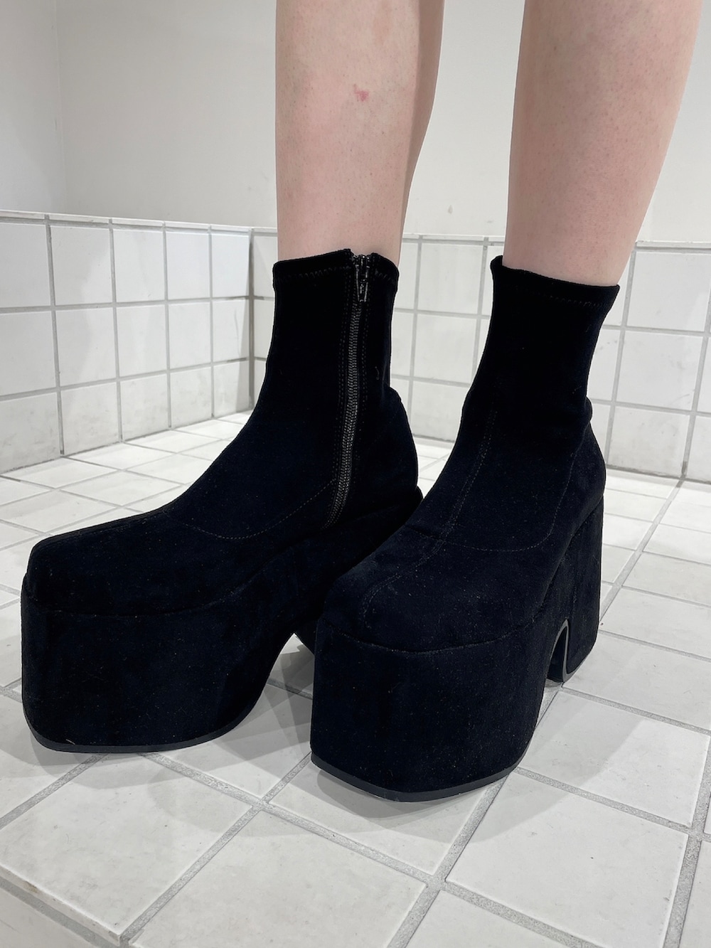 ホワイト系のニット/セーター、ブルー系のデニムパンツ、ブラック系のブーツを着用したレディースの秋コーディネートの9枚目の写真