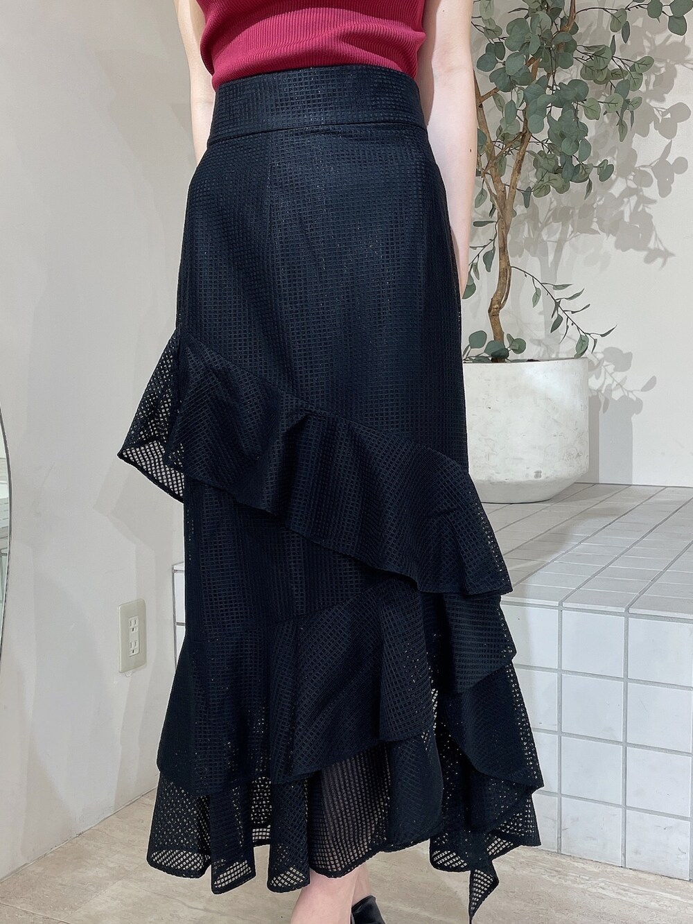 ブラック系のサンダル、レッド系のニット/セーター、ブラック系のスカートを着用したレディースの夏コーディネートの6枚目の写真