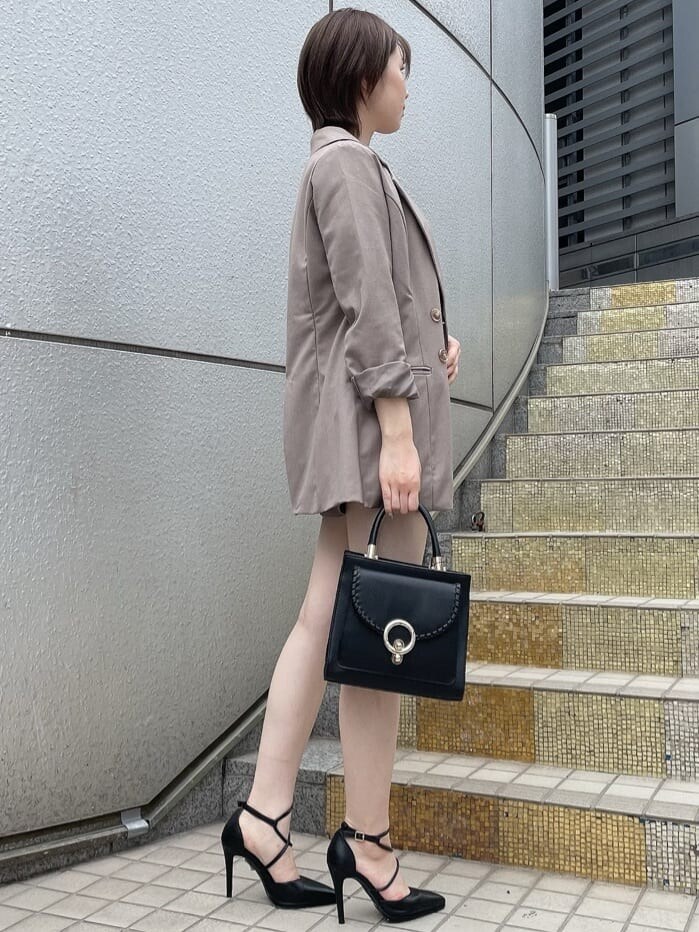 ベージュ系のテーラードジャケット、ブラック系のハンドバッグ、ベージュ系のその他パンツを着用したレディースの夏コーディネートの3枚目の写真