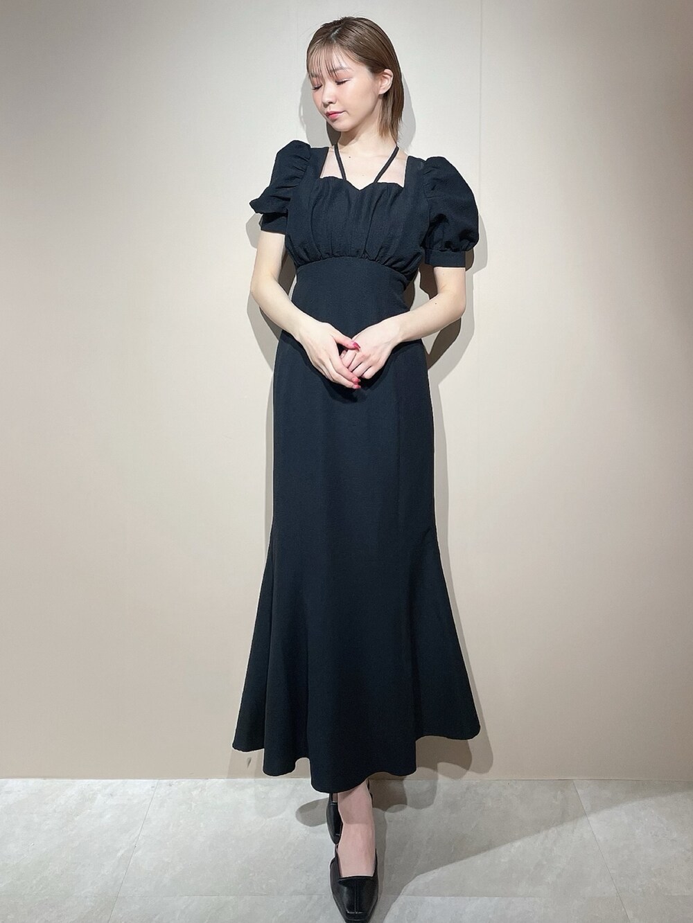 ブラック系のワンピース、ブラック系のパンプスを着用したレディースの春コーディネートの3枚目の写真