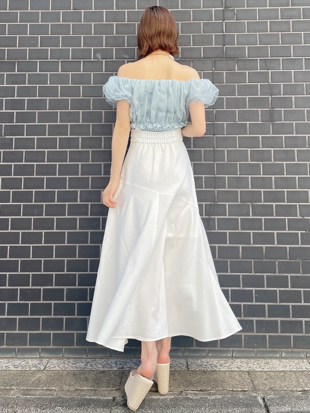 ブルー系のシャツ/ブラウス、ホワイト系のスカート、ホワイト系のサンダルを着用したレディースの春コーディネートの4枚目の写真