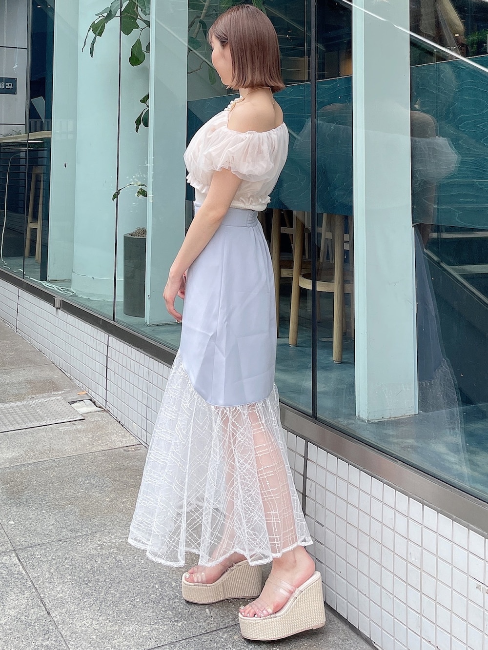 ホワイト系のシャツ/ブラウス、ブルー系のスカート、ホワイト系のサンダルを着用したレディースの夏コーディネートの4枚目の写真