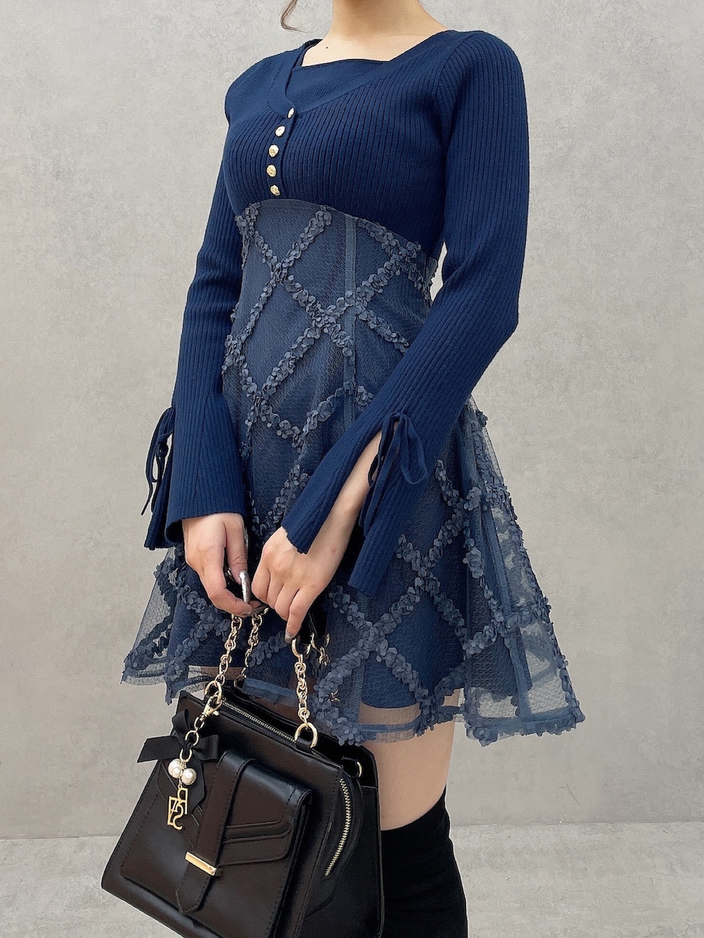 ブルー系のワンピース、ブラック系のハンドバッグ、ブラック系のブーツを着用したレディースの秋コーディネートの5枚目の写真