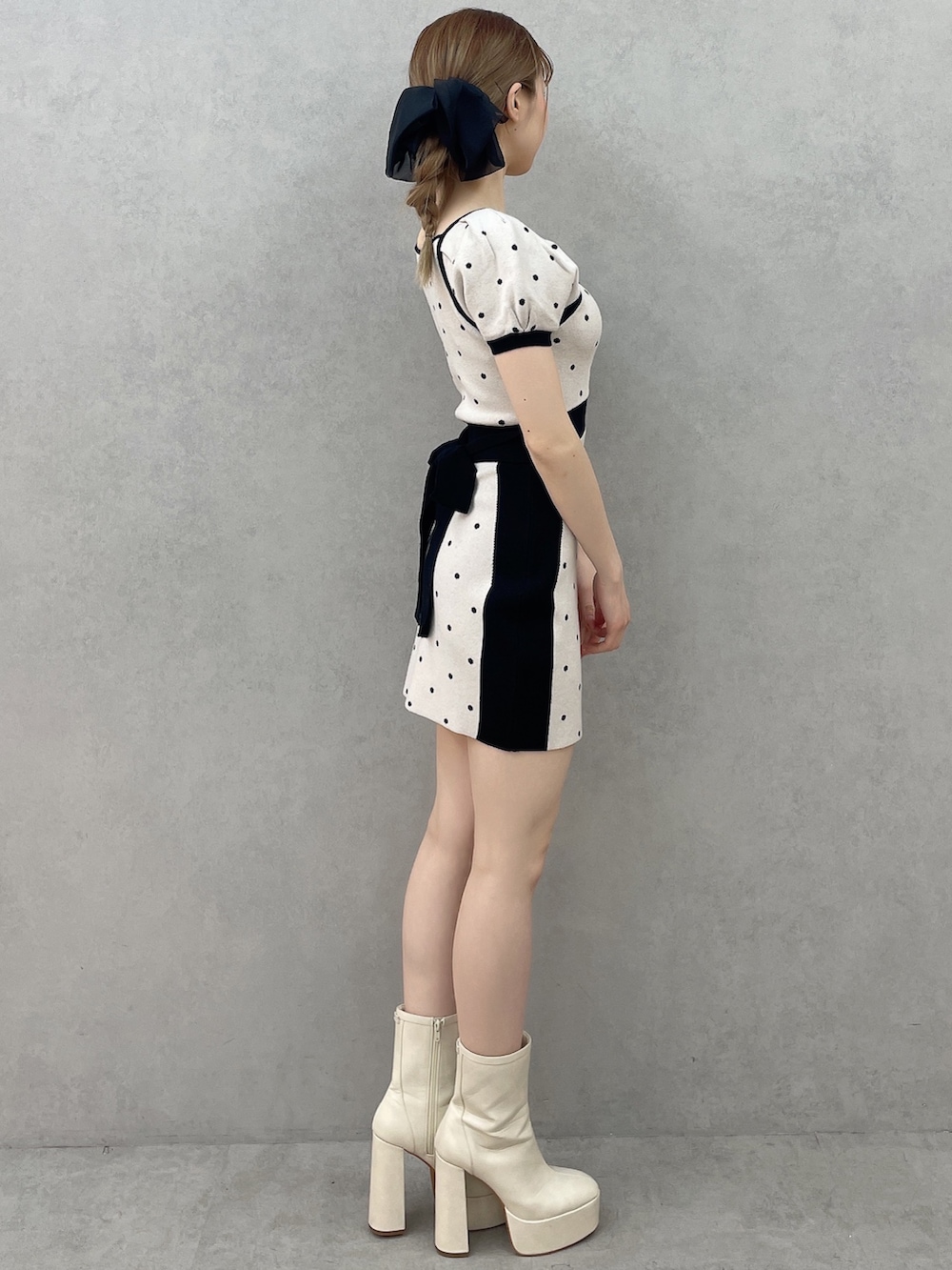 ブラック系のワンピース、ホワイト系のブーツ、ブラック系のバレッタ/ヘアクリップを着用したレディースの春コーディネートの3枚目の写真