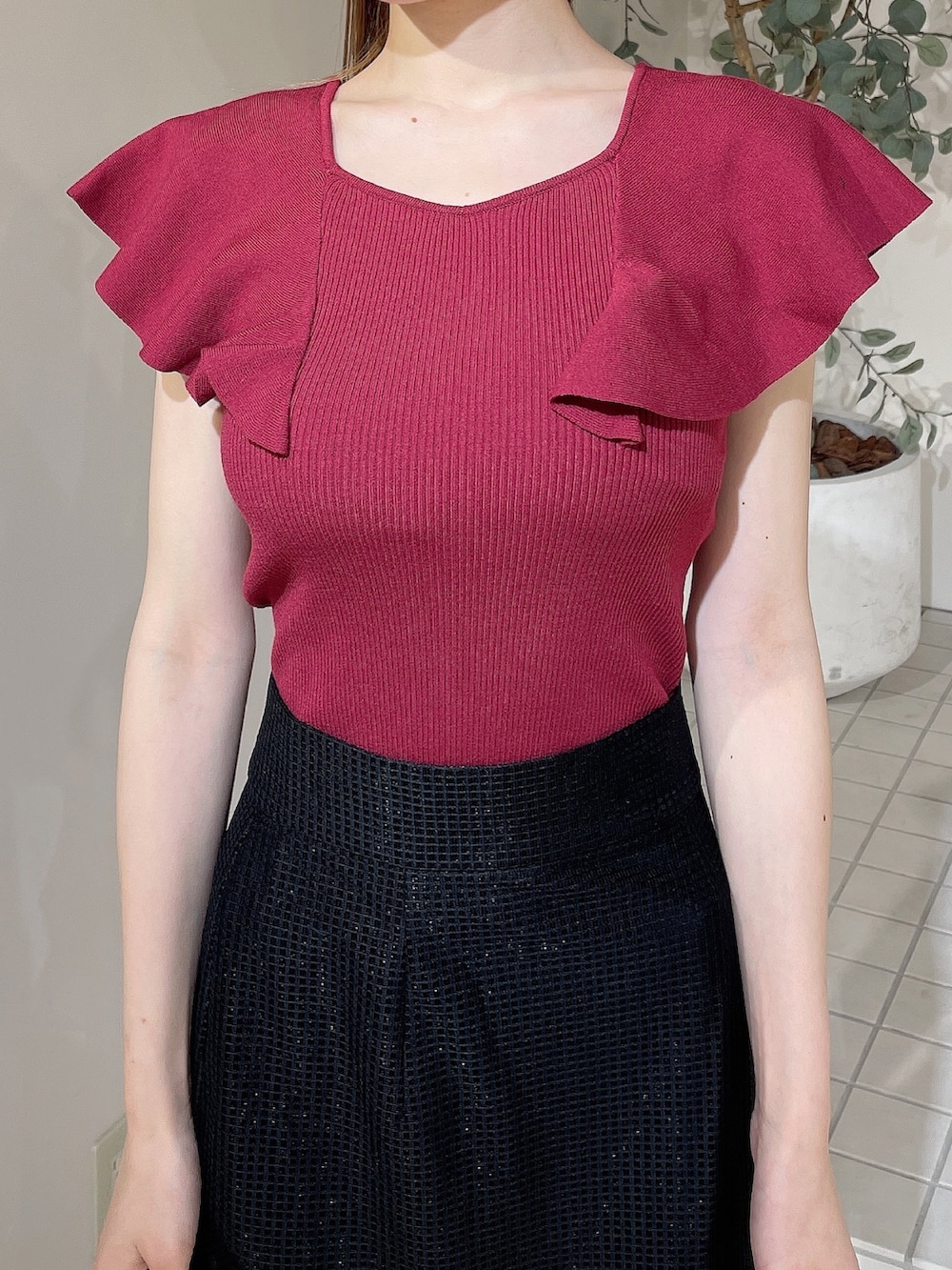 ブラック系のサンダル、レッド系のニット/セーター、ブラック系のスカートを着用したレディースの夏コーディネートの4枚目の写真