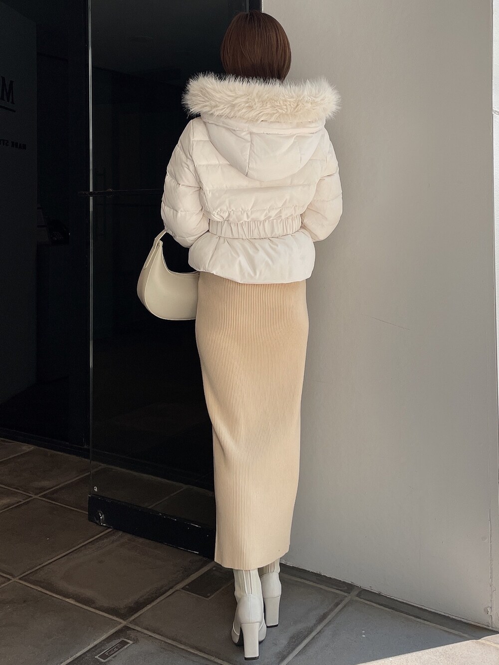 ホワイト系のダウンジャケット/コート、ホワイト系のワンピース、ホワイト系のブーツを着用したレディースの秋コーディネートの4枚目の写真