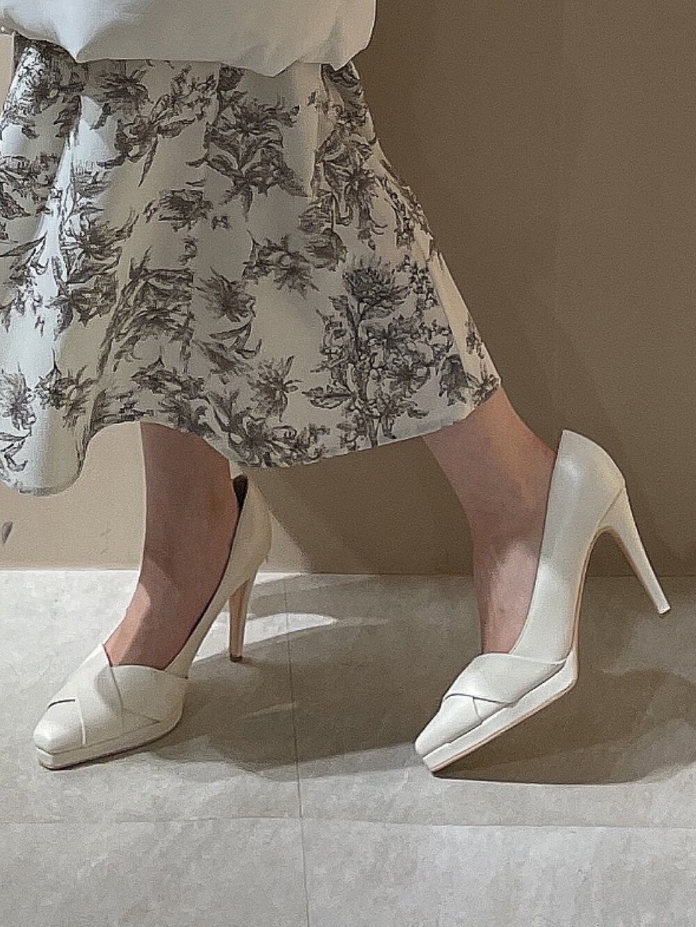 グレー系のワンピース、ホワイト系のパンプス、ホワイト系のチェスターコートを着用したレディースの秋コーディネートの7枚目の写真